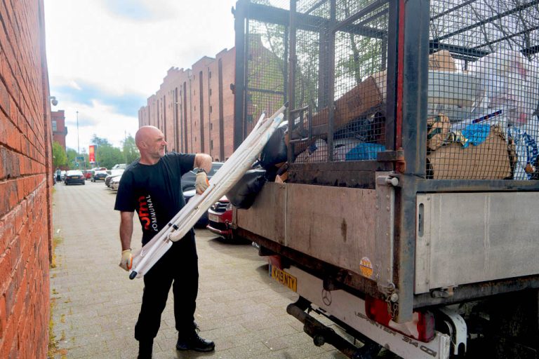 Form employee getting rid of waste into the back of a truck during an end of tenancy cleaning