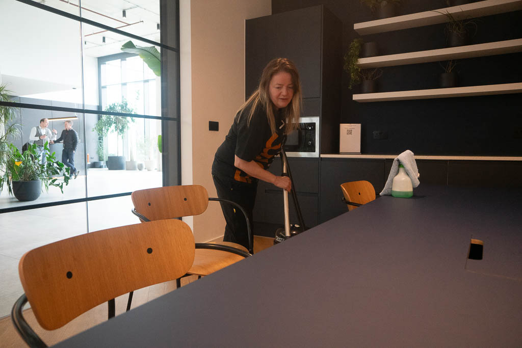 Form Communal employee vacuuming an office space