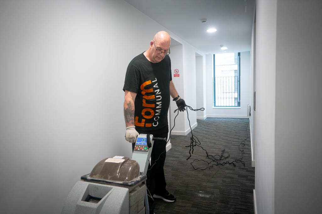 Form Communal employee with carpet cleaner machine